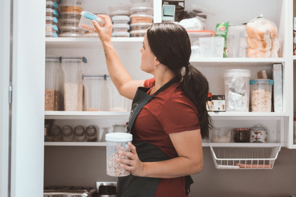 Female Putting Away Kitchen Container