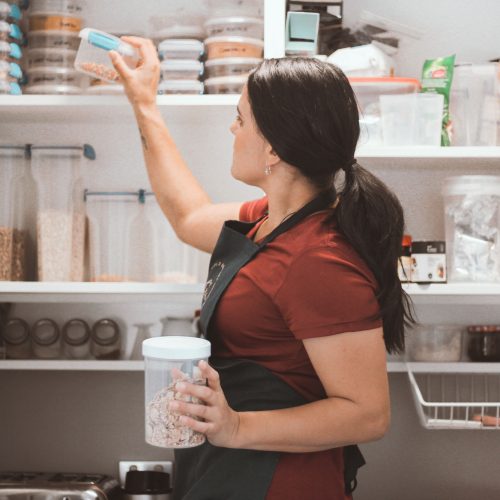 Female Putting Away Kitchen Container